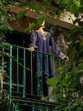 Person standing on a balcony with greenery around